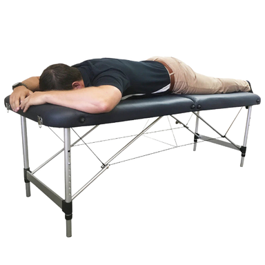 Man laying on Blue AllCare massage table