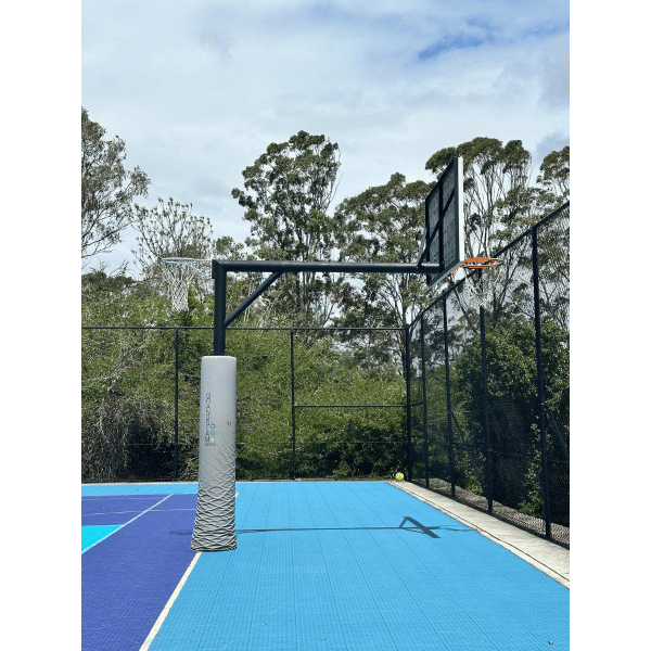  Grand Slam Reversible Basketball Tower on a blue fenced court with trees in the background