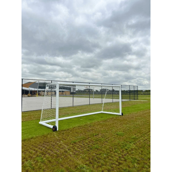 Grand Slam Senior Aluminium Soccer Goals on a grass field with a cloudy sky fenced area in background
