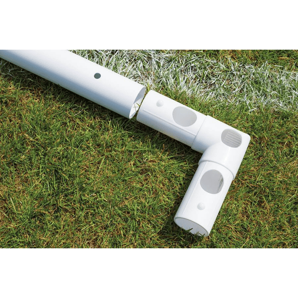 HART Samba Match Goals – white plastic corner joint connecting tubular goalposts on green grass field with white boundary line.