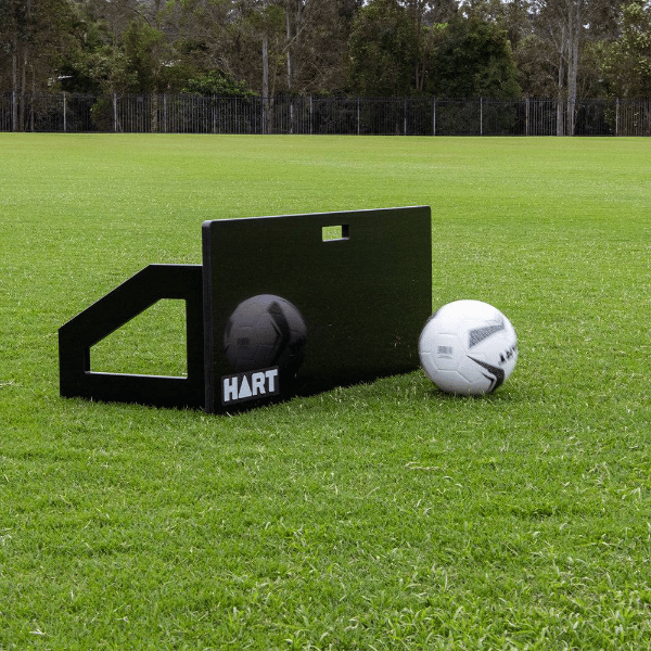 HART Soccer Rebound Board on soccer field with soccer ball on green grass