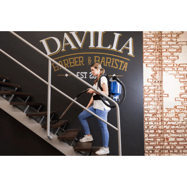 Person with the Pacvac Superpro Go Cordless Backpack Vacuum walking up stairs 